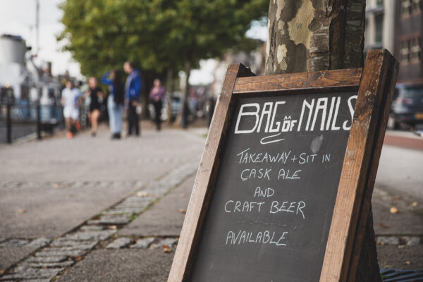 Pub sign for the Bag of Nails, Bristol, with a stylised cat making up part of the letter "o" in the word "of"