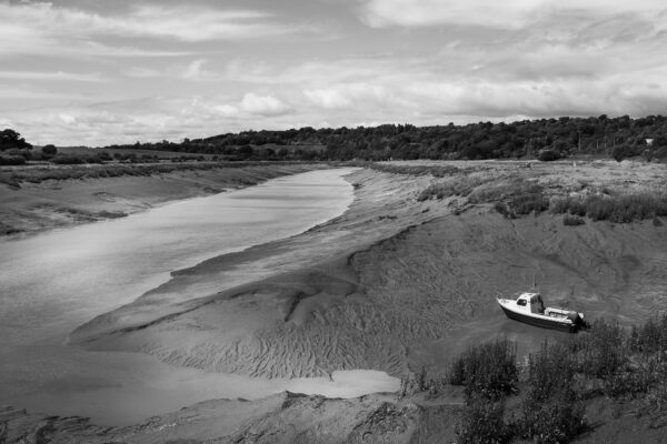 A boat rests on the bank of the River Avon at Sea Mills