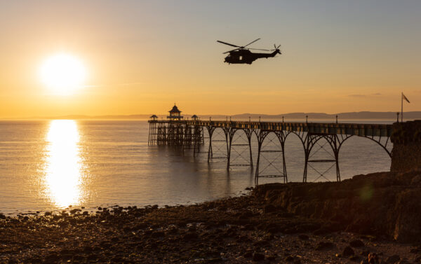 A Puma helicopter crosses Clevedon Pier at sunset