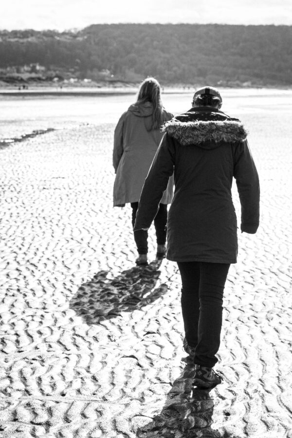 My friends Sarah and Vik in near-silhouette walking along the beach at Sand Bay, away from the camear.